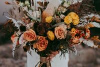 a bright fall wedding bouquet of blush, yellow blooms, dark foliage, dried leaves and greenery is a cool and chic idea