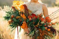 a bright fall wedding bouquet of greenery, bold fall foliage, twigs and leaves plus berries is adorable for a fall wedding