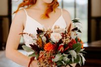 a colorful fall bridal crown with deep red, burgudy and orange blooms, foliage and greenery is a lovely idea