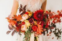 a colorful fall wedding bouquet of blush, red and burgundy blooms, dark foliage and berries is a fantastic idea for a fall wedding