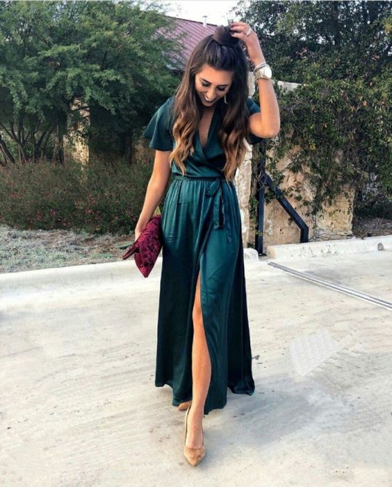 a dark green wrap midi dress with short sleeves, a floral clutch and nude shoes for a fall wedding