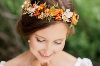 a delicate and bright fall wedding crown of orange and rust bloo,s white blooms, pinecones and berries is a very pretty idea