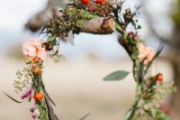 a delicate fall wedding wreath of greenery, blush and fuchsia blooms and berries is a pretty decoration for the fall