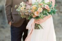 a delicate wedding bouquet with blush and lilac blooms plus foliage of various shades and pink ribbons