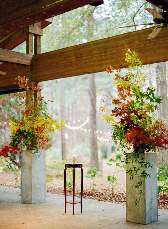 a fall wedding altar done with greenery and bold leaves is a fantastic idea for a modern fall wedding