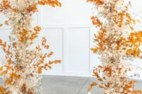 a fall wedding arch decorated with bold fall leaves, cotton, dried branches is a colorful and cool idea for the fall