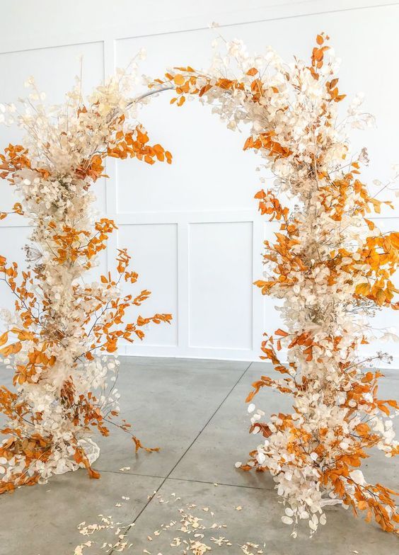 a fall wedding arch decorated with bold fall leaves, cotton, dried branches is a colorful and cool idea for the fall