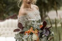 a fall wedding bouquet of white and orange blooms, greenery and dark foliage is amazing for a moody wedding