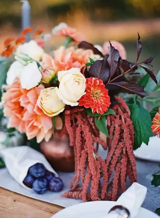 a fall wedding centerpiece of white roses, red mums, pink dahlias, dark foliage and greenery and amaranthus is a cool idea