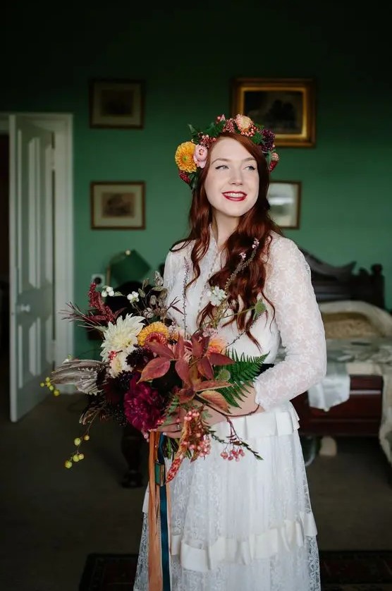 a fall woodland bride wearing a bright florla crown and carrying a matching super bold wedding bouquet with greenery and berries