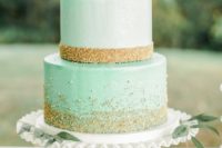 a glam mint wedding cake with gold glitter and beads and some fresh roses on top