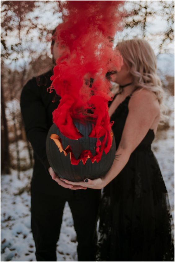 a gorgeous Halloween wedding portrait with a black Jack-o-lantern with red smoke is fantastic and absolutely jaw-dropping