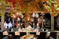 a gorgeous oversized fall leaf hanging over the reception with candles looks fall-like like no other