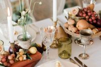 a harvest wedding tablescape with vintage books, fruit, berries, pears, roses and some candles is a very refined idea for the fall