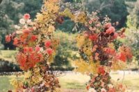 a jaw-dropping wedding arch for the fall decorated with fall blooms, white, coral, blush and burgundy dahlias