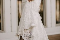 a lace A-line wedding dress with a train and brown patterned cowboy boots for a rustic and very chic bridal look at a fall wedding