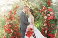 a lovely and refined Valentine’s Day wedding altar with red and blush roses and greenery looks extremely romantic and very chic