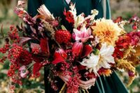 a lush and textural fall woodland wedding bouquet with colorful leaves, herbs and blooms