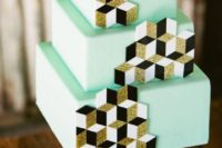 a mint green wedding cake decorated with white, black and gold glitter cubes for decor