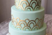 a mint green wedding cake with gold patterns is a stylish and glam option for a modern wedding