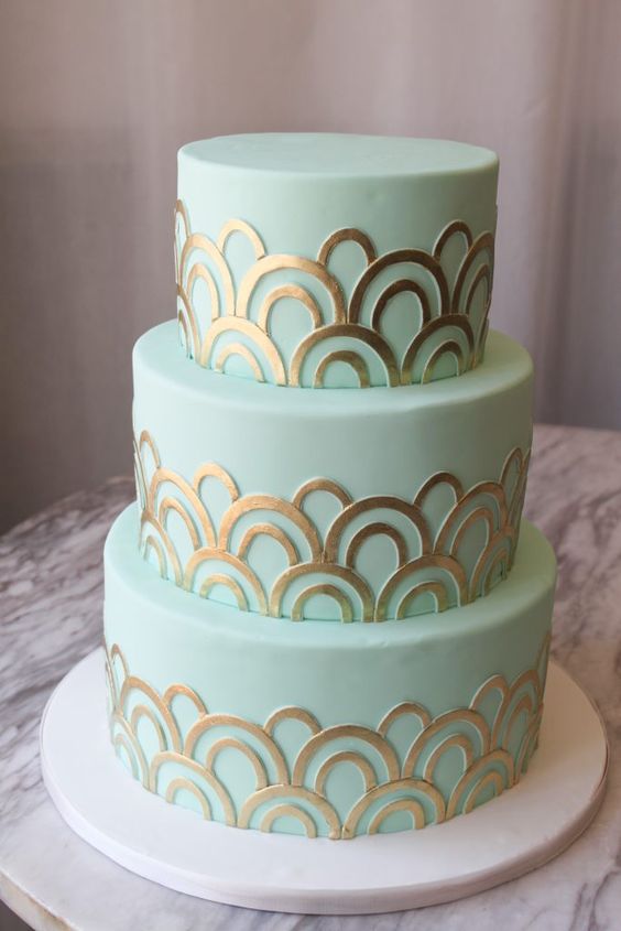 a mint green wedding cake with gold patterns is a stylish and glam option for a modern wedding