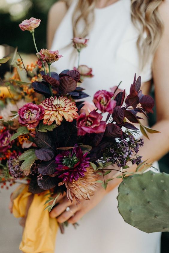a moody fall wedding bouquet of pink and burgundy blooms, dark foliage and mustard ribbon is wow