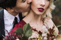 a moody floral crown with deep red, berries, greenery and dark foliage is a lovely idea for a fall boho bride