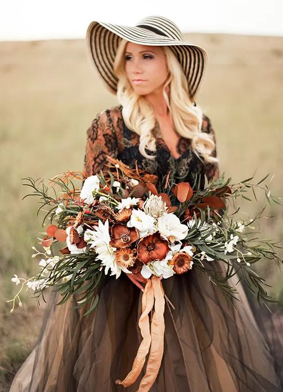 a moody wedding bouquet done in the shades of brown and rust plus white blooms and neutral ribbons