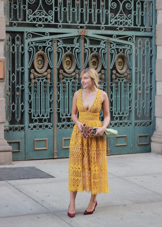a mustard lace midi sleeveless dress with a plunging neckline, burgundy shoes and statement earrings for a wow look