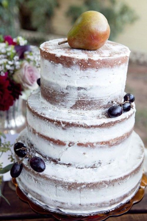 a naked wedding cake decorated with grapes and topped with a pear is a lovely idea for a fall boho wedding