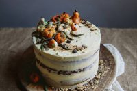 a naked wedding cake topped with sugar pumpkins and leaves is a lovely idea for a fall wedding
