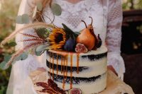 a naked wedding cake with caramel drip, figs, pears, greenery and sunflowers on top is a fantastic boho fall wedding
