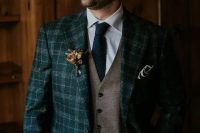 a navy plaid pantsuit, a grey waistcoat, a white shirt, a navy tie and a bold boutonniere are a chic and cool combo for the fall