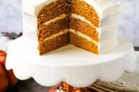 a pumpkin spice wedding cake with cream cheese frosting and macarons on top is a lovely idea for a modern fall wedding