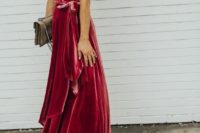 a red velvet wrap maxi dress with short sleeves, tan shoes and a matching small bag