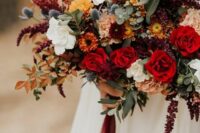 a refined and colorful fall wedding bouquet of white, orange and red blooms, greenery, bold foliage and amaranthus