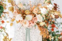 a refined fall wedding bouquet of white, blush and peachy blooms, berries and bold fall foliage is amazing