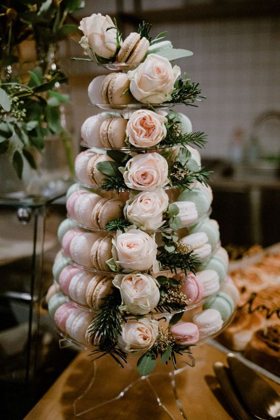 a refined pastel macaron tower with blush, pink and green desserts, greenery and blush roses is a refined idea
