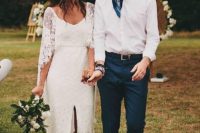 a relaxed and bold groom’s outfit with navy pants, a printed navy tie and hat plus a white shirt