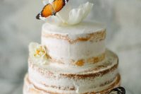 a semi-naked wedding cake decorated with white blooms and faux butterflies is a cute and fairy-tale-like piece