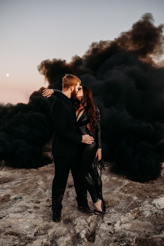 a sexy Halloween engagement photo with the couple in black and black smoke around just wows