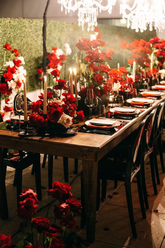 a sophisticated wedding ablescape with red and blush roses, blush candles, black placemats and red napkins is amazing for a Halloween wedding