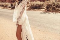 a stylish boho bridal look with a white boho lace wedding dress wiht a train, a neutral hat, black and white printed boots