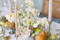 a subtle wedding centerpiece of neutral blooms and twigs and pears and grapes is a lovely idea for a neutral wedding tablescape