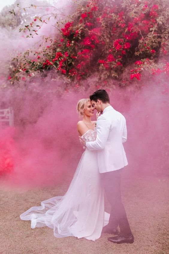 a super romantic wedding portrait with blooming branches and pink smoke is a very beautiful and delicate idea