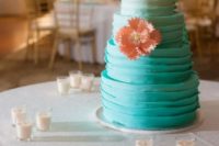 a textural ombre tiffany blue wedding cake with a cool topper and a sugar coral bloom for decor