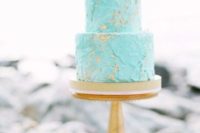 a textural tiffany blue wedding cake decorated with gold leaf is a trendy and edgy idea