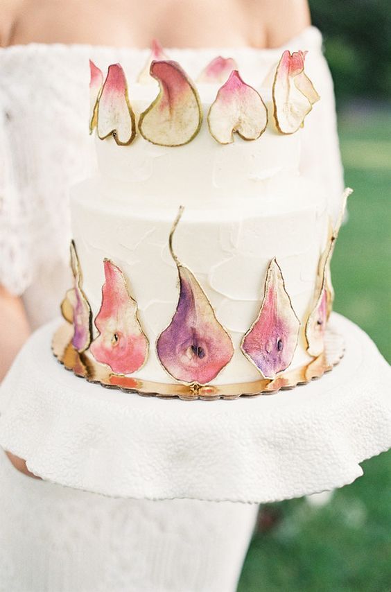 a unique white buttercream wedding cake decorated with colorful pear slices is a lovely solution for a fall boho wedding