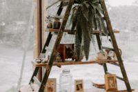 a vintage wedding decoration of a ladder, a potted plant, artworks, a wood slice and vintage decor