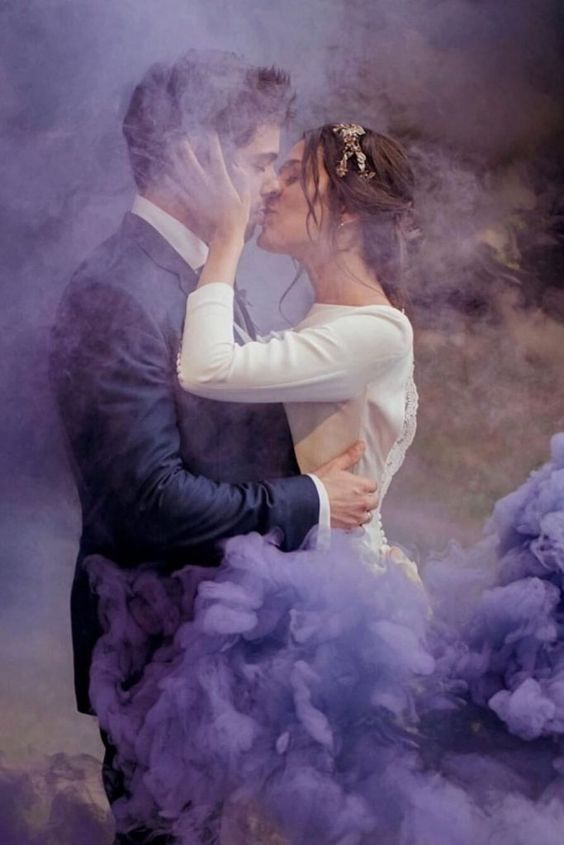 a wedding portrait done right in the purple smoke looks breathtaking and very romantic